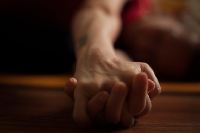A close-up shot of two hands clasped together on a wooden surface, conveying intimacy and connection.