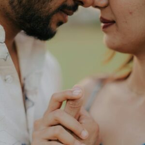 A tender and intimate close-up of a couple holding hands, emphasizing affection and connection.