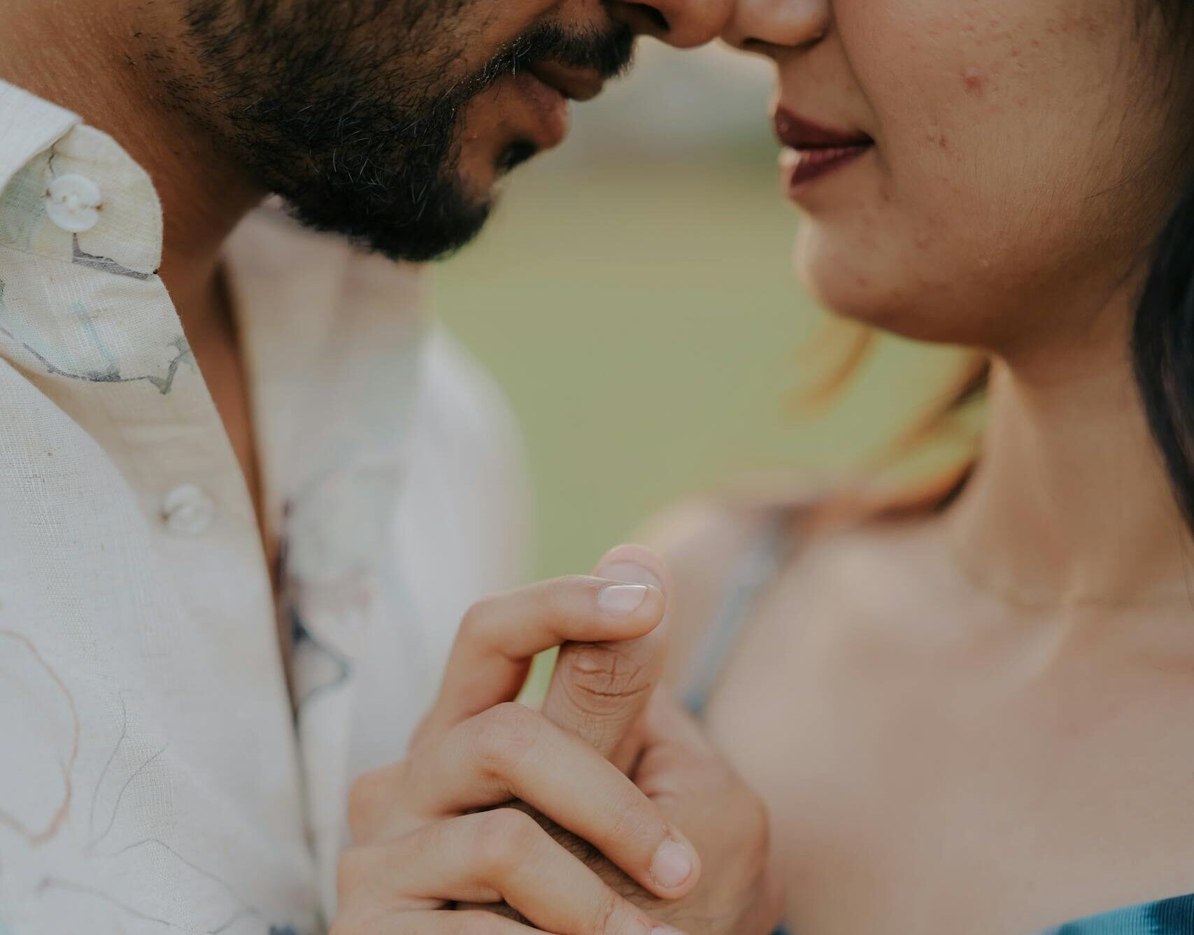A tender and intimate close-up of a couple holding hands, emphasizing affection and connection.